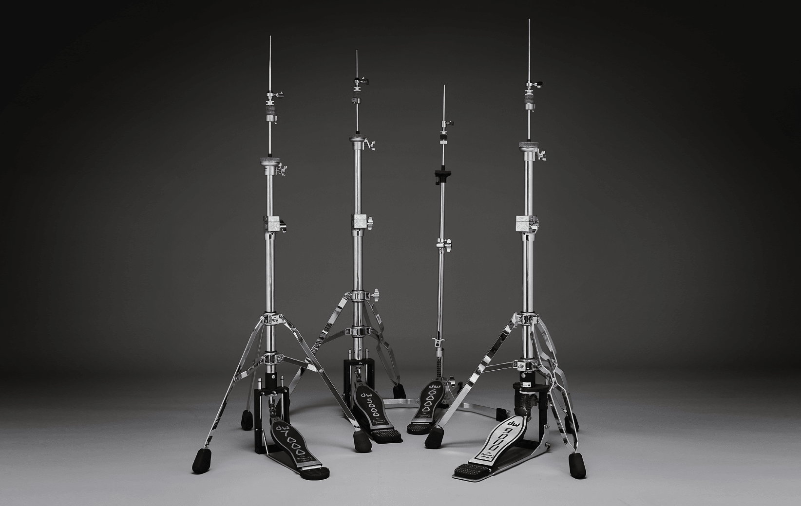 A collection of hi-hat stands including a single-braced DW 7000 Series stand, a two-legged DW 5000 Series stand, a low-profile DW Series stand, and a double-braced DW 9000 hi-hat stand.