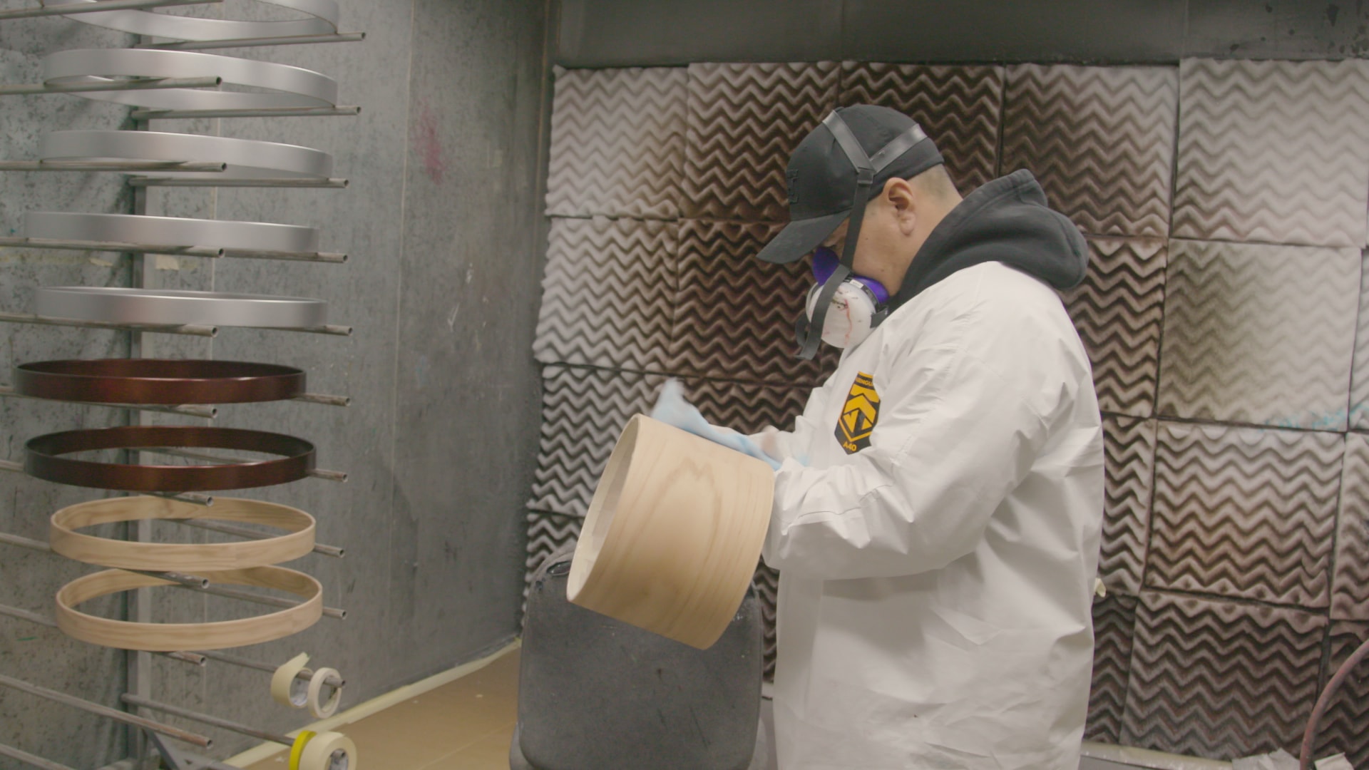 DW painter holding a drum shell in the paint booth